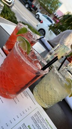 two cocktails sitting on top of a table next to each other