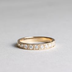 a gold wedding band with five diamonds