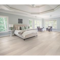 a large bedroom with hardwood floors and white furniture