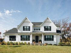 a large white house sitting on top of a lush green field