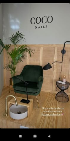 a green chair sitting on top of a wooden table next to a potted plant