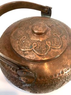 an old tea kettle with ornate designs on it