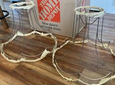 three wire baskets sitting on top of a hard wood floor next to a cardboard box