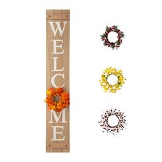 three wreaths are placed next to a welcome sign with the word welcome on it