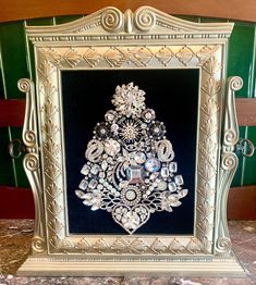 an ornate gold frame with jewels and pearls in the shape of a christmas tree on it