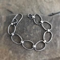 This sterling silver bracelet has 7 chain links, textured with my favourite hammer. The links are connected with small oval links, which are approximately 3 mm wide Links are approximately 2 cm long and 1.4 cm wide. Handcrafted clasp. Oxidised to highlight the textures. Total length of the bracelet is 19.5 cm / 7.67 inch, including the clasp. If the bracelet is too long, you can easily cut off one or two small links with a wire cutter from your toolbox, and shorten it with approximately 13 mm. T Silver Oval Link Chain Bracelet, Sterling Silver Oval Link Chain Bracelet, Sterling Silver Bracelets With Oxidized Finish And Chain Link, Oxidized Metal Bracelet With Oval Links, Silver Oval Chain Bracelet For Everyday, Sterling Silver Oxidized Link Chain Bracelet, Sterling Silver Bracelet With Oval Links, Oxidized Metal Chain Bracelet With Oval Links, Sterling Silver Chain Link Bracelet With Hooks