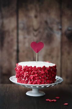 a red and white cake with hearts on top