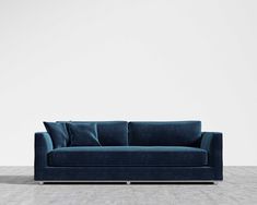 a blue couch sitting on top of a wooden floor next to a white wall in an empty room