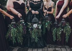 a group of women standing next to each other wearing dresses and holding vases with flowers on them