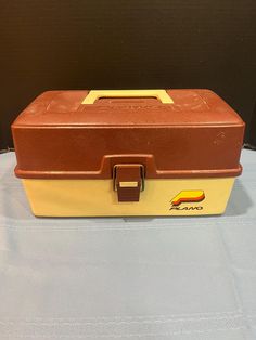 a brown and yellow suitcase sitting on top of a table