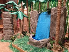 an artificial water slide in the middle of a jungle with palm trees and other plants