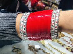 a close up of a person's arm with bracelets on it