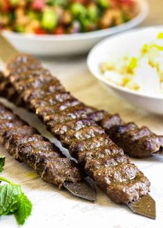 there are several different types of meat on the table with rice and vegetables in bowls