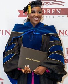 a woman wearing a graduation gown and holding a diploma