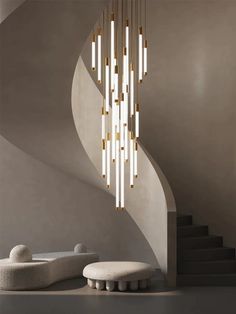 a modern chandelier hanging from the ceiling in a room with white walls and stairs