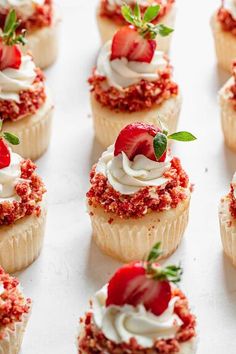 cupcakes with strawberries and cream on top are lined up in rows, ready to be eaten