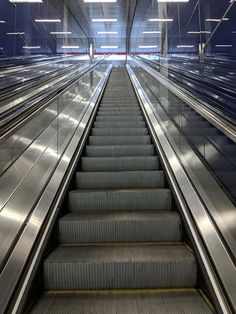 an escalator with stairs leading up to the top