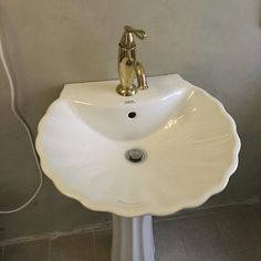 a bathroom sink with a faucet on the side and a shower head in the corner