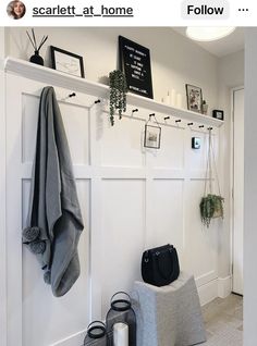 a white coat rack with towels and other items on it next to a gray chair