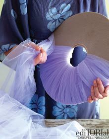 a woman holding a purple fan in her hands and wearing a blue kimono with flowers on it