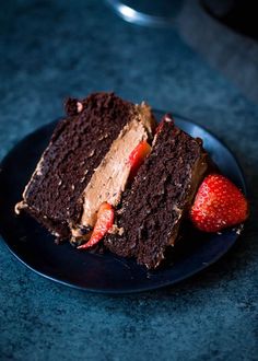 a piece of chocolate cake on a plate with strawberries