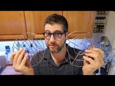 a man is holding two metal circles in his hands and looking up at the camera