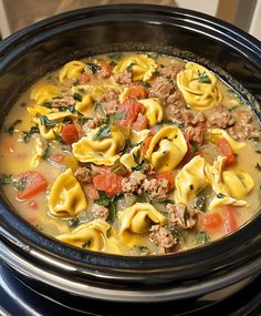 a crock pot filled with pasta and meat soup