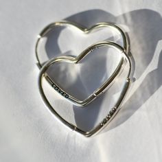 Introducing our contemporary twist on a timeless symbol: asymmetrical heart hoop earrings, meticulously crafted in gleaming sterling silver. Each hoop is fashioned into an elegant heart, embodying the beautifully unique nature of love itself. These earrings are not only a stylish accessory but also a reminder that love is never perfect, and it's the quirks that make it truly special. Features: Sculptural Elegance: Asymmetrical heart design for a modern aesthetic. Lustrous Finish: High-shine 925 sterling silver captures the light, emphasizing the fluidity of the heart's shape. Statement Size: At a height of 30mm, these earrings are designed to be noticed, making them an ideal focal point for any outfit. Versatile Style: Wear these heart hoops on their own for a chic look or incorporate them Birthday Presents For Friends, Sterling Silver Cleaner, Timeless Symbol, Silver Cleaner, Heart Hoop Earrings, Unique Nature, Heart Shaped Earrings, A Symbol, Presents For Friends