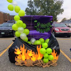 there is a large purple bag with green balloons on it and fire in the street