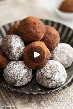 a bowl filled with chocolate covered donuts on top of a table