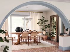 a dining room table with chairs and vases on it's centerpiece in front of an arched doorway