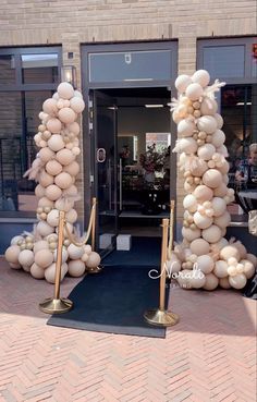 an entrance to a building with balloons on the ground and poles in front of it