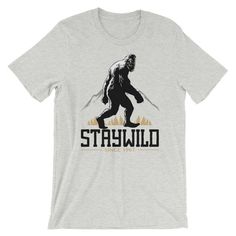 Bigfoot Stay Wild This top selling updated unisex essential fits like a well-loved favorite, featuring a crew neck, short sleeves and designed with superior Airlume combed and ring-spun cotton. *100% No Sweatshops & Eco-Friendly *It's comfortable and flattering for both men and women. *Features: Sideseamed. Retail fit. Unisex sizing. Shoulder taping. *Tear-away label Fabrication: Solid Colors: 100% Airlume combed and ring-spun cotton, 32 single 4.2 oz. (Ash - 99% Airlume combed and ring-spun Gray Crew Neck T-shirt For Outdoor Activities, Short Sleeve T-shirt With Logo For Outdoor Activities, Short Sleeve Logo Print T-shirt For Outdoors, Crew Neck T-shirt With Letter Print For Outdoor, Logo Print T-shirt For Outdoor Activities, Stay Wild, T Shirt Photo, Prism Color, Ash Color