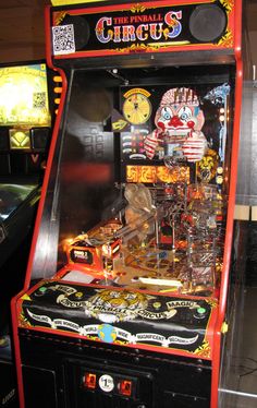 an old fashioned pinball machine with clowns on it's sides and buttons