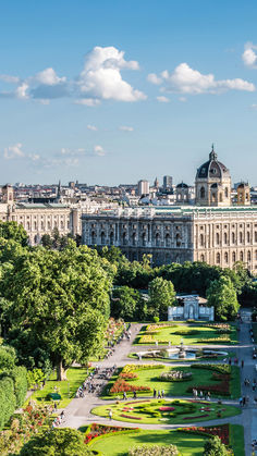 an aerial view of a city with lots of trees and flowers in the foreground