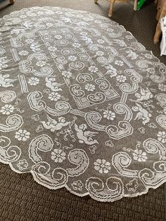 a white doily sitting on top of a carpeted floor