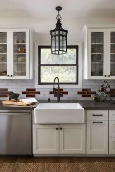 a clean kitchen with white cabinets and stainless steel dishwasher in the center island