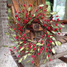 a wooden rocking chair with red berries and green leaves on the front door handle,