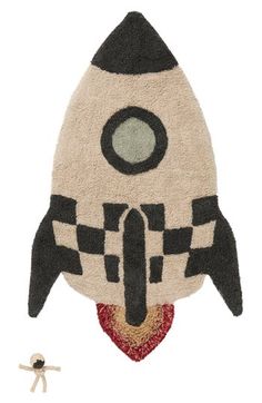 a rug with a rocket ship on it's side and a small figure next to it