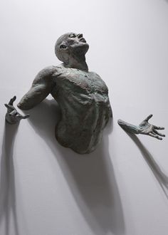 a sculpture of a man holding two hands up