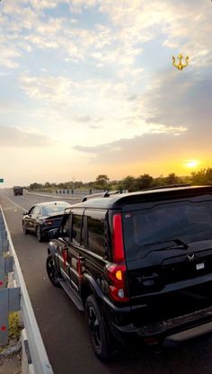 several cars are driving down the highway at sunset