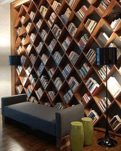 a living room filled with furniture and bookshelves next to a wall full of books