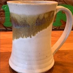 a white and brown cup sitting on top of a wooden table