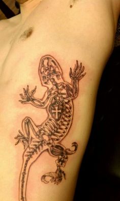 a man with a tattoo on his arm that has a lizard and cross on it