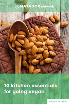 a wooden spoon filled with almonds on top of a table