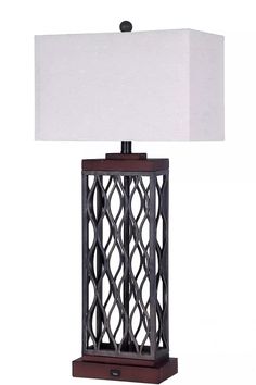 a table lamp with a white shade on it's side and a wooden base