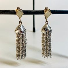 "Add a touch of vintage charm to your outfit with these stunning Sarah Coventry clip-on earrings. The silver tone dangle chain and tassel design is perfect for any occasion, from weddings to birthdays and everything in between. The rectangle shape and clip-on closure make them easy to wear. Approximately 2\" long and 1/2\" wide. These earrings are a wonderful addition to any jewelry collection. The signed Sarah Coventry brand ensures their originality and adds a touch of authenticity to your accessories. Don't miss out on these one-of-a-kind earrings that are sure to turn heads wherever you go." Silver Fringe Metal Earrings, Silver Tassel Earrings For Evening, Silver Dangle Tassel Earrings With Fringe, Elegant Silver Tassel Earrings With Fringe, Formal Metal Tassel Drop Earrings, Silver Metal Chandelier Earrings With Tassels, Elegant Silver Nickel-free Tassel Earrings, Elegant Drop Clip-on Earrings With Latkans, Elegant Silver Tassel Earrings Nickel Free