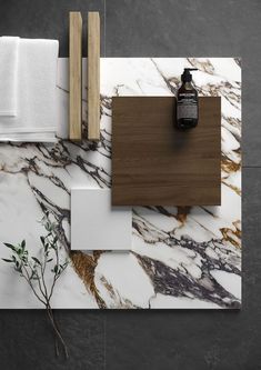 a bathroom counter with marble and wood on it, next to a bottle of lotion