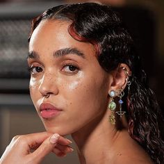 a woman with freckles on her face looking off to the side while wearing gold earrings