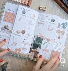 a person is holding up a planner with her hands on the table next to it